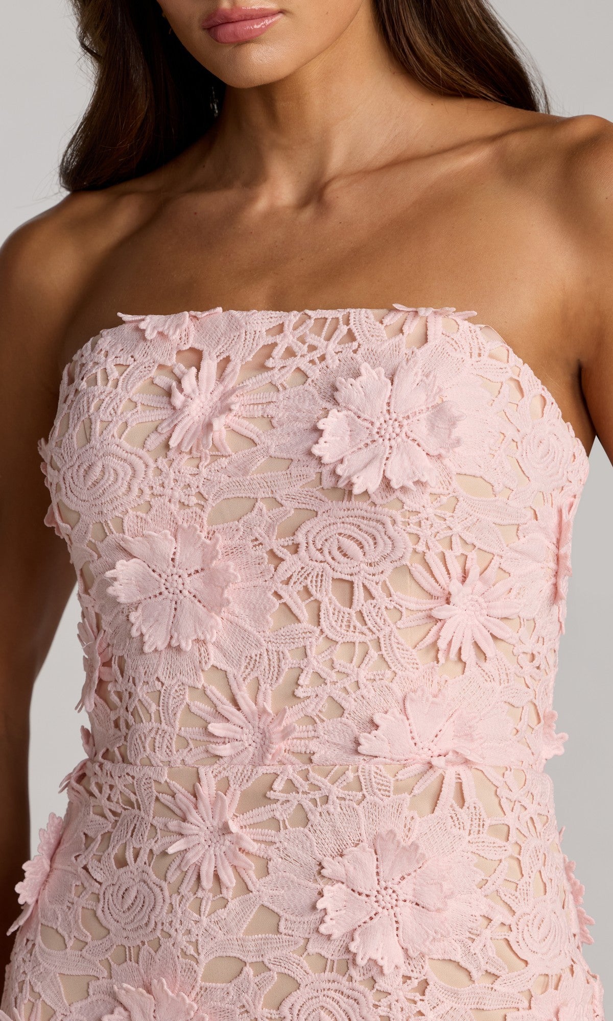 Woman wearing the Midi Party Dress: Mac Duggal 50117, a strapless light pink floral lace midi dress featuring intricate 3D floral applique and delicate flower patterns, shown from shoulders to waist.
